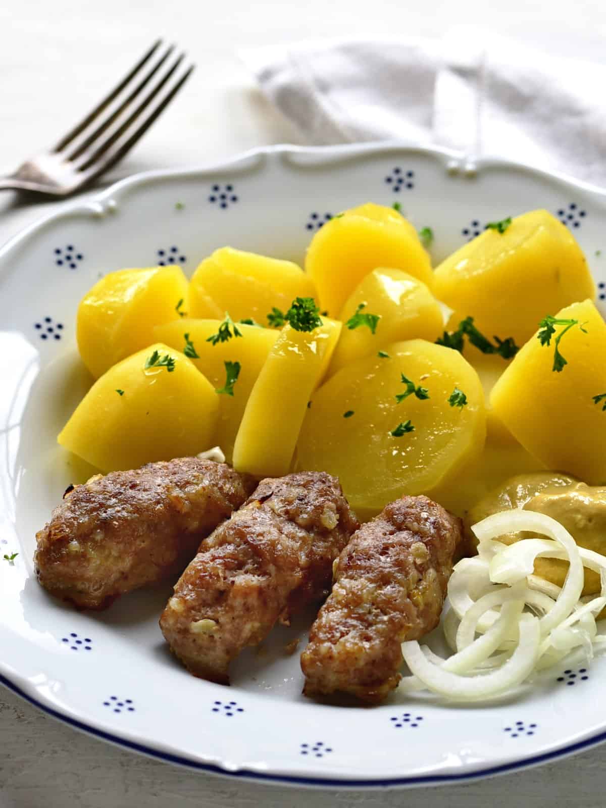 cevapcici serviert mit kartoffeln