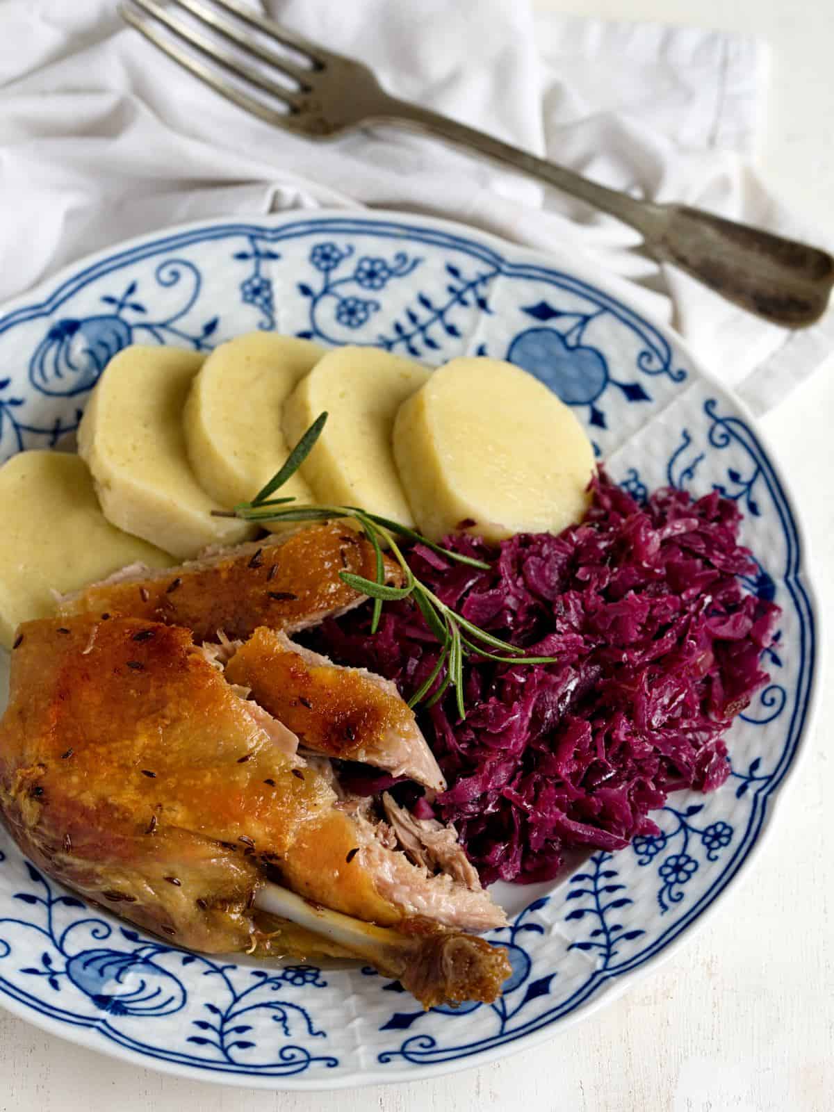 Entenbraten serviert mit Knödeln und Rotkohl.