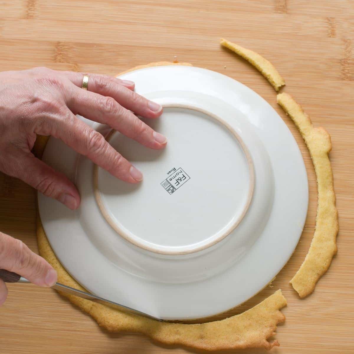 Kuchenboden auf die Form des Tellers zuschneiden.