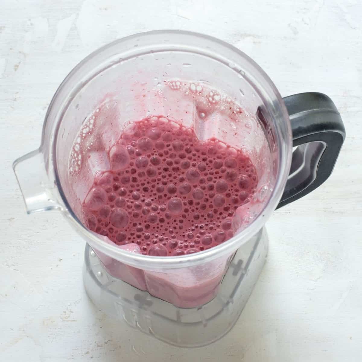 Aufgeschäumter Milchshake mit Erdbeeren im Standmixer.