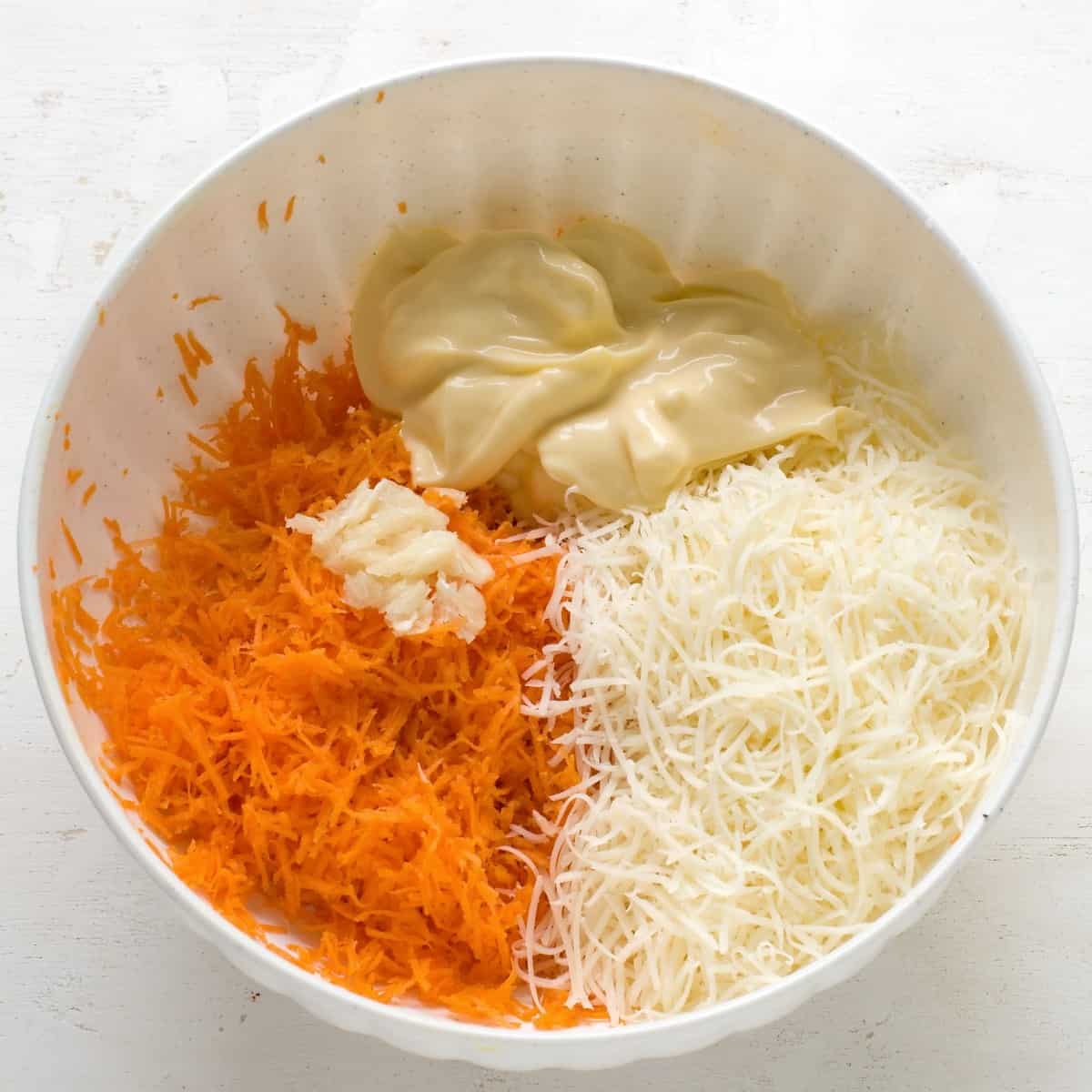 Zutaten für Karotten-Käse Aufstrich in weisser Schüssel.
